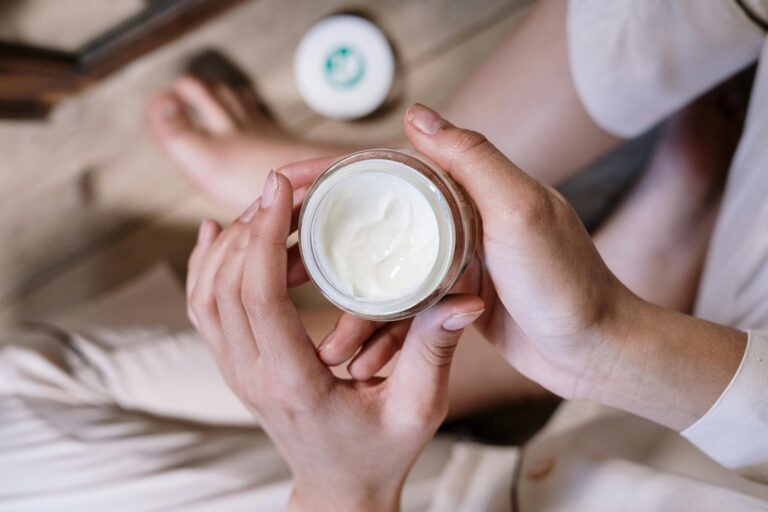 Two hands effortlessly applying Esque Solution cream, with a clean and minimalist background to emphasize the simplicity of the skincare routine